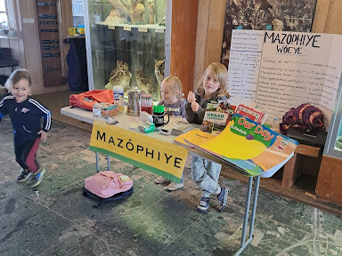 Three young children at a table at Bdé Psíŋ (Lake Hiawatha) rec center getting ready to plant rice